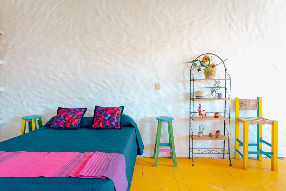 Maximalistische woonkamer met kleurrijke kunstwerken.